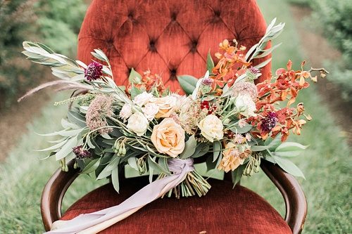Beautiful winter inspired flowers on chairs moments with specialty and vintage rentals by Paisley & Jade