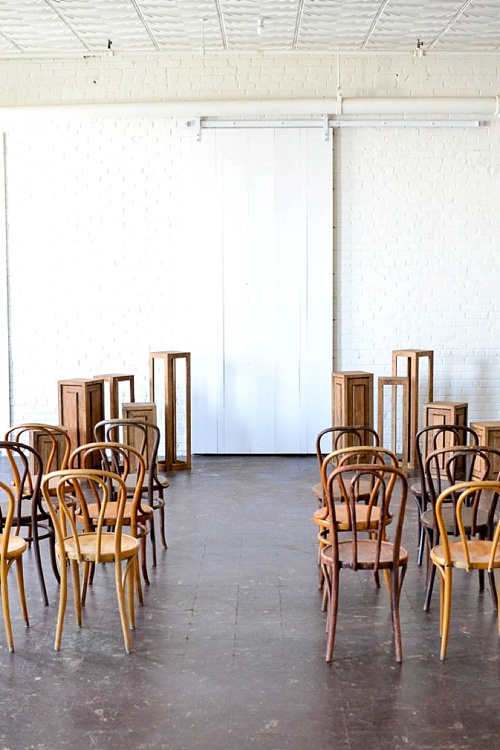 Inspiration Station wedding ceremony design featuring wooden pedestals and chairs available for rent by Paisley and Jade 