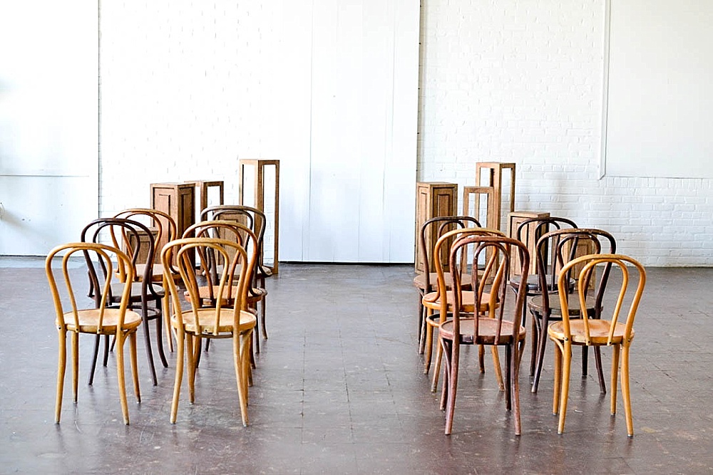 Inspiration Station wedding ceremony design featuring wooden pedestals and chairs available for rent by Paisley and Jade