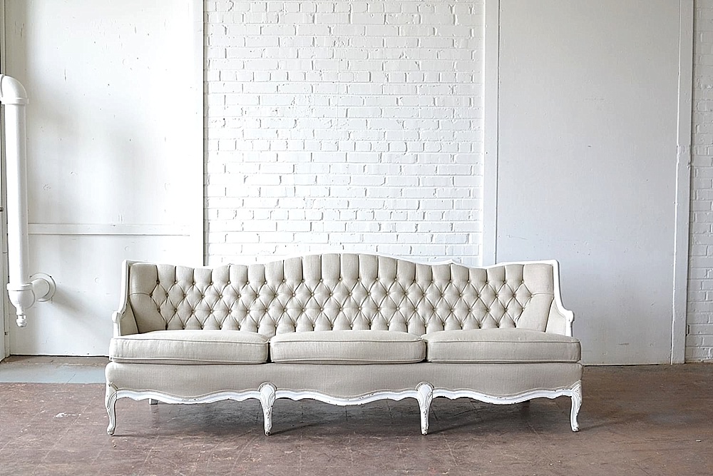 The fabulous Fulton Sofa from Paisley and Jade is a perfect piece for any style of event with its gray upholstery and white wooden trim