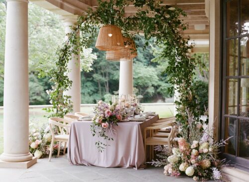 freestanding pendants holding the jute and seagrass chandeliers over a dining table with the lovell dining chairs at bramblewood estate for an outdoor dinner